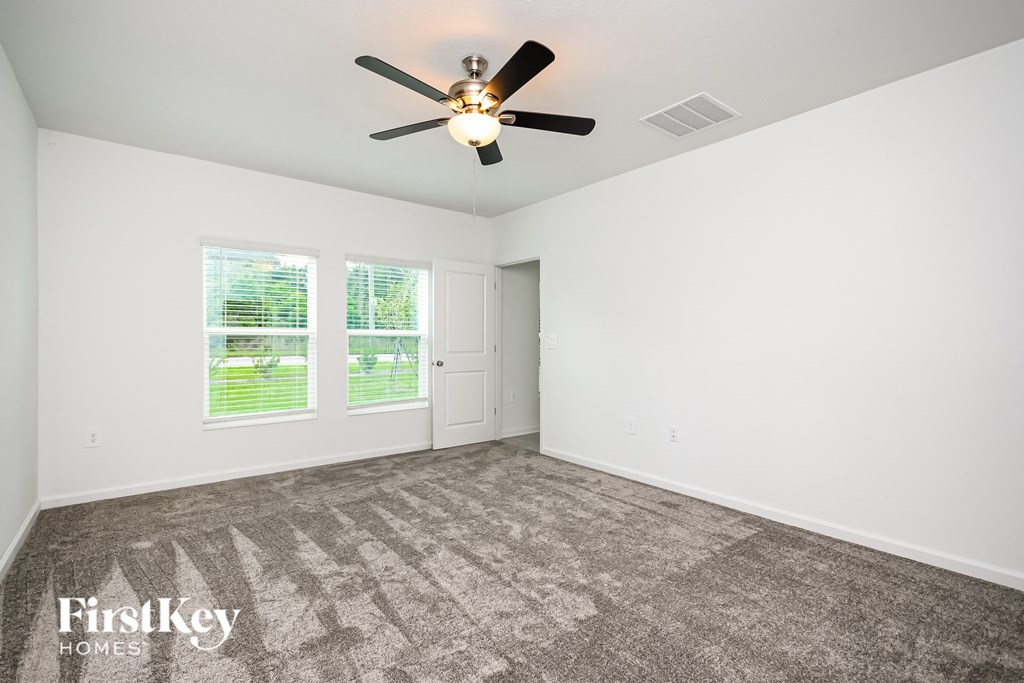a living room with carpet and a ceiling fan