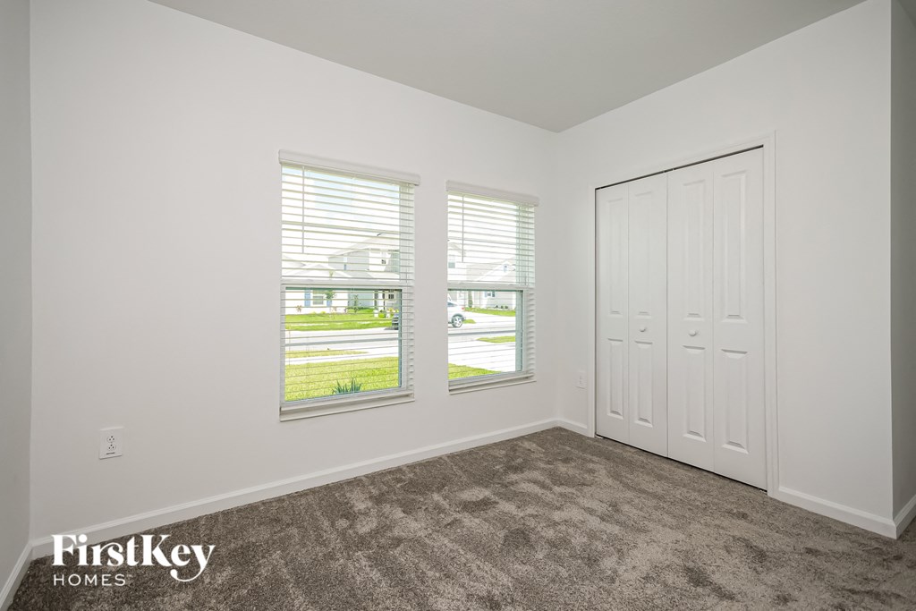 the living room of a home with carpet and two windows