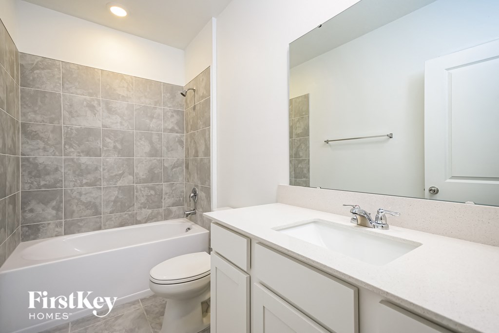 a white bathroom with a white sink and toilet and a tub