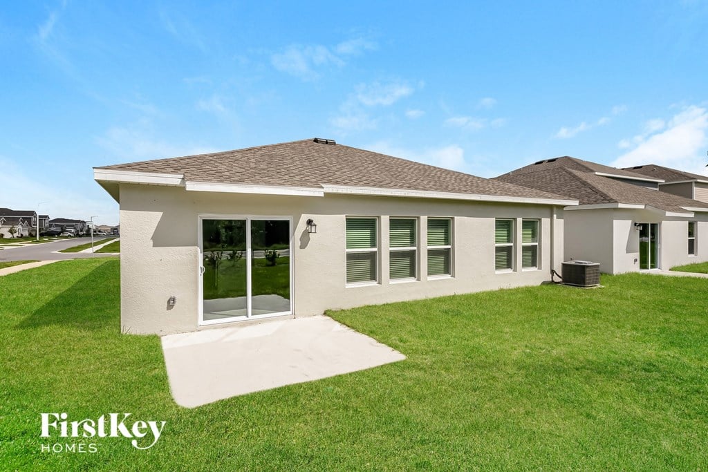a small white house with a lawn and a driveway