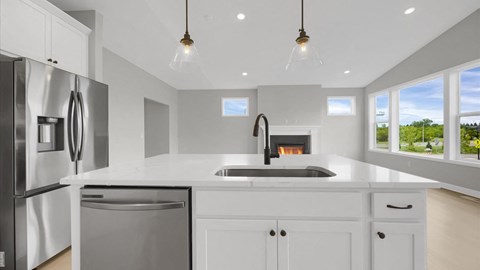 a white kitchen with a sink and a refrigerator