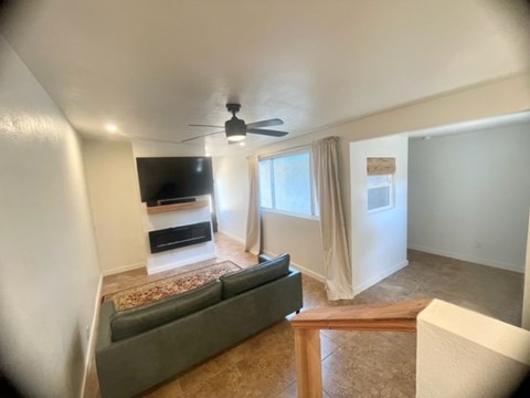 A living room with a grey couch and a television.