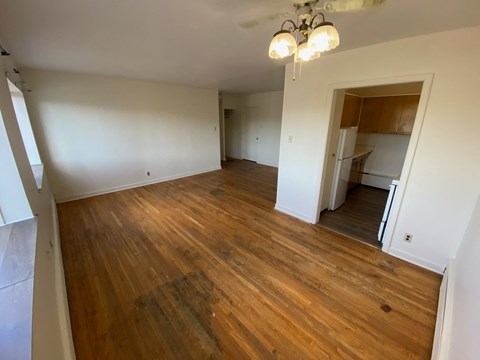 an empty living room with wood flooring in an empty house