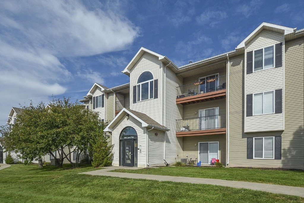 the front of a house with a sidewalk and grass