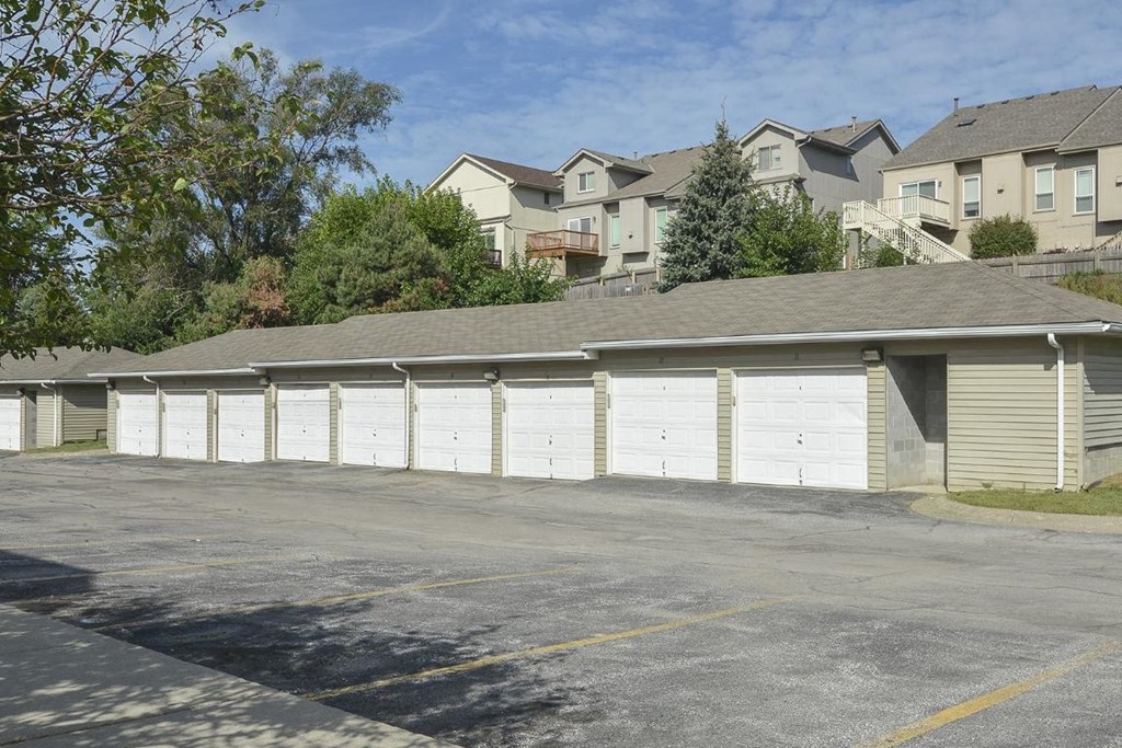 a row of white garage doors in a parking lot