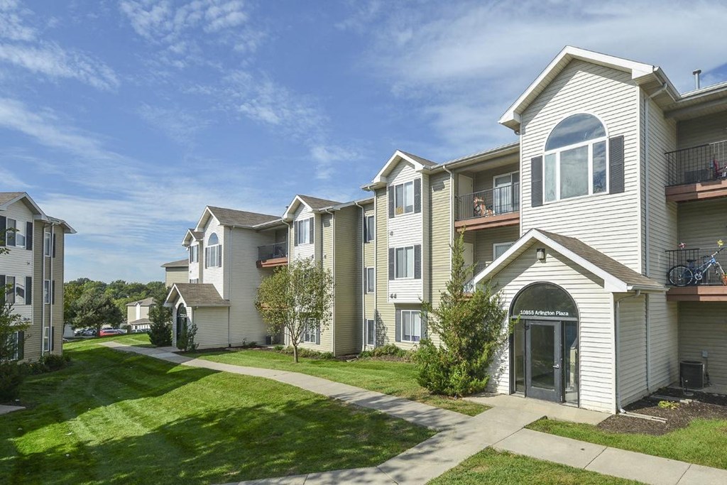 a row of houses with a sidewalk and grass