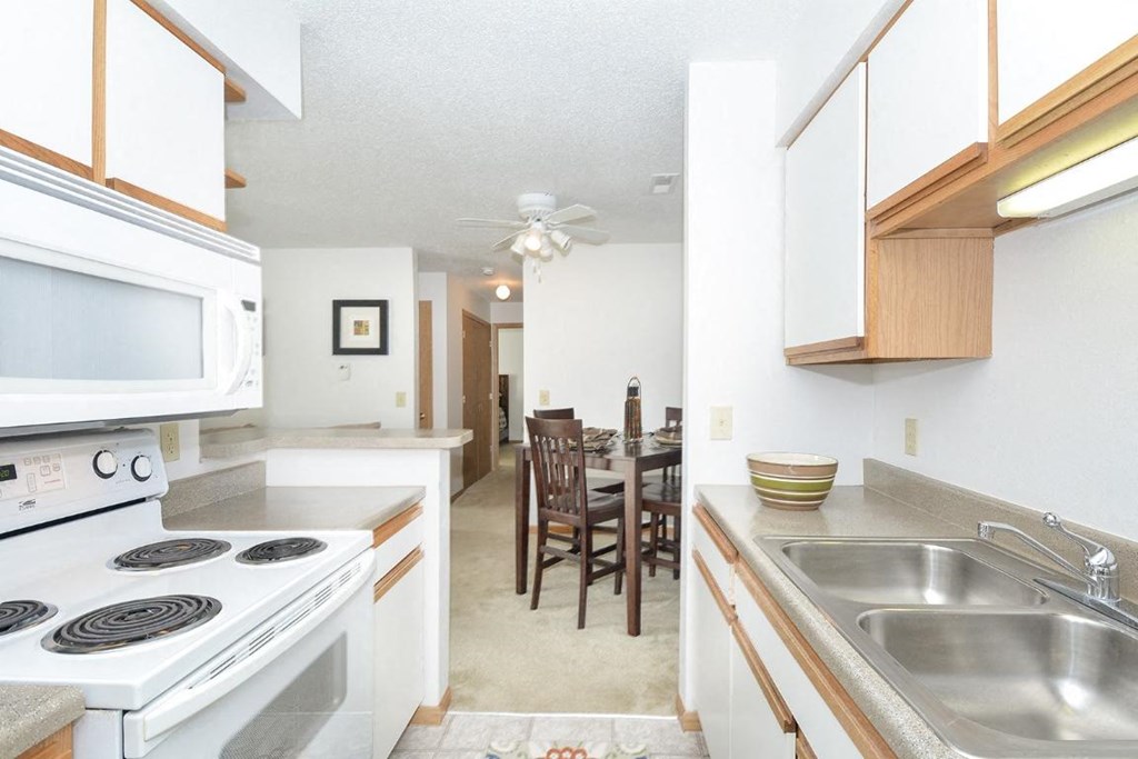 a kitchen and dining room with a stove microwave and sink