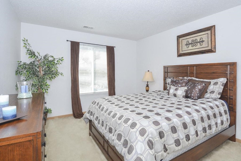 a bedroom with a bed and a dresser and a window