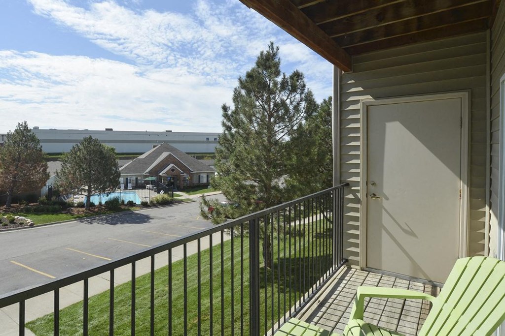 a balcony with a door and chairs on it