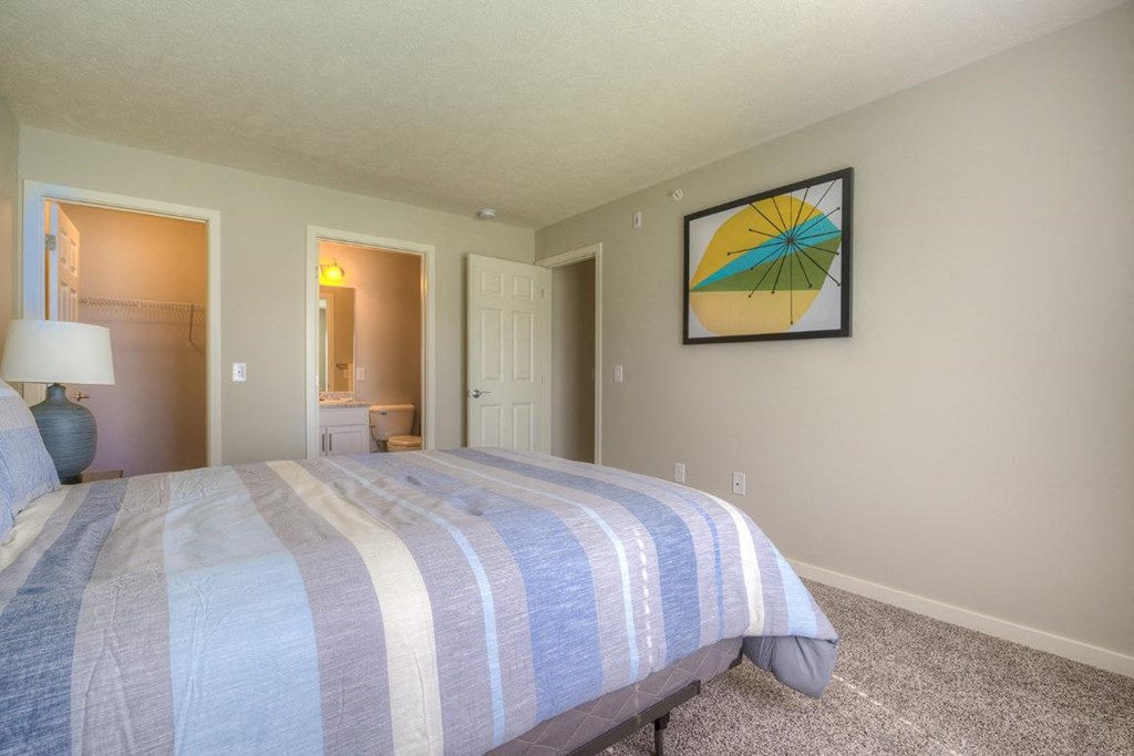 a bedroom with a bed and a door to a bathroom