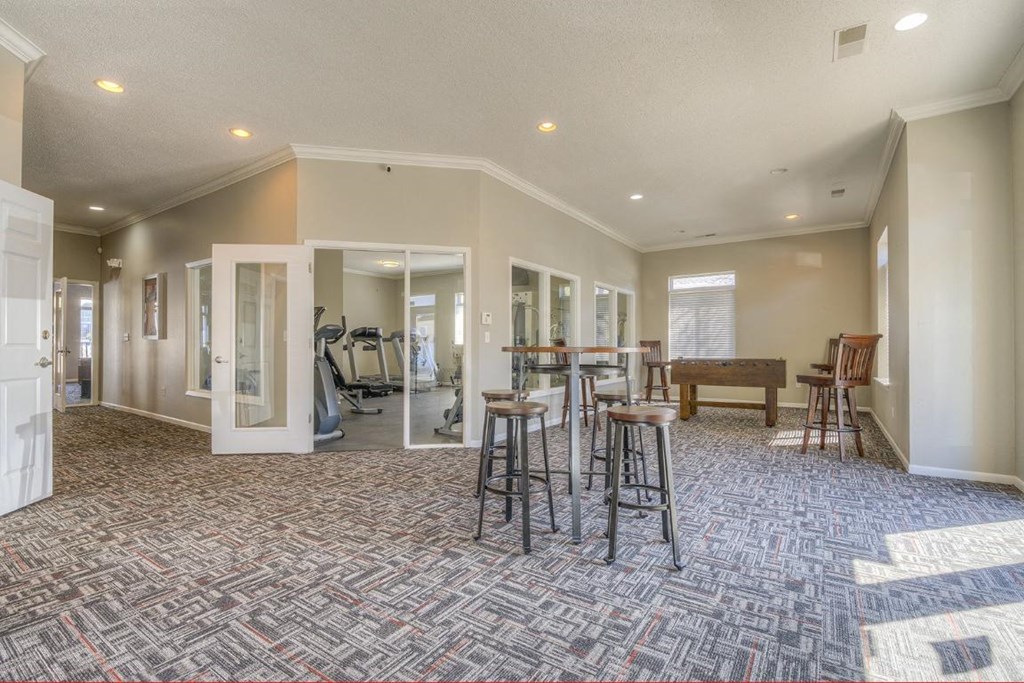 a clubhouse with a bar and chairs and a pool table