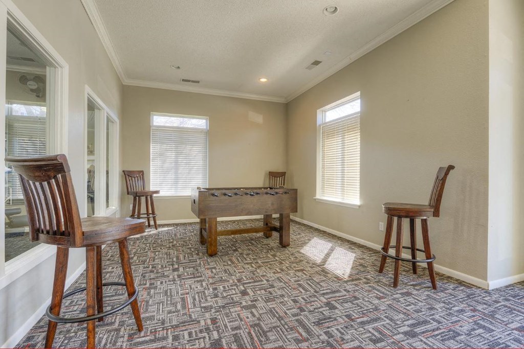 a game room with a pool table and chairs