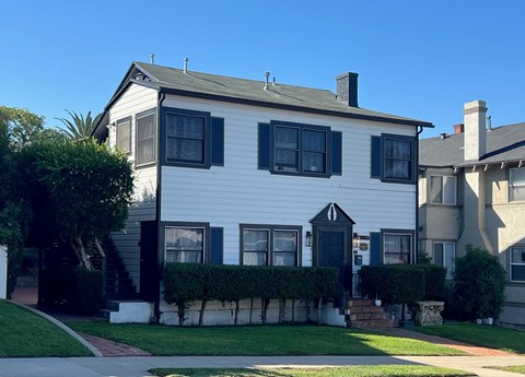A white house with black shutters and a black door.