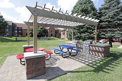 a picnic area with a pergola and a table with benches