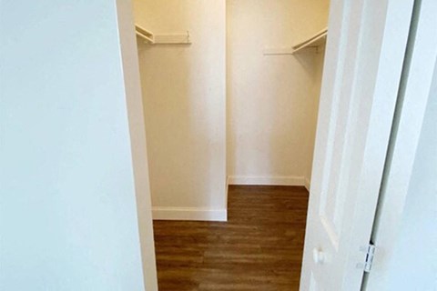 a room with white walls and wooden floors and a closet