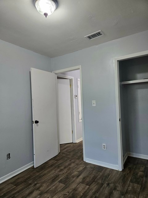 A room with a white door and a grey wall.