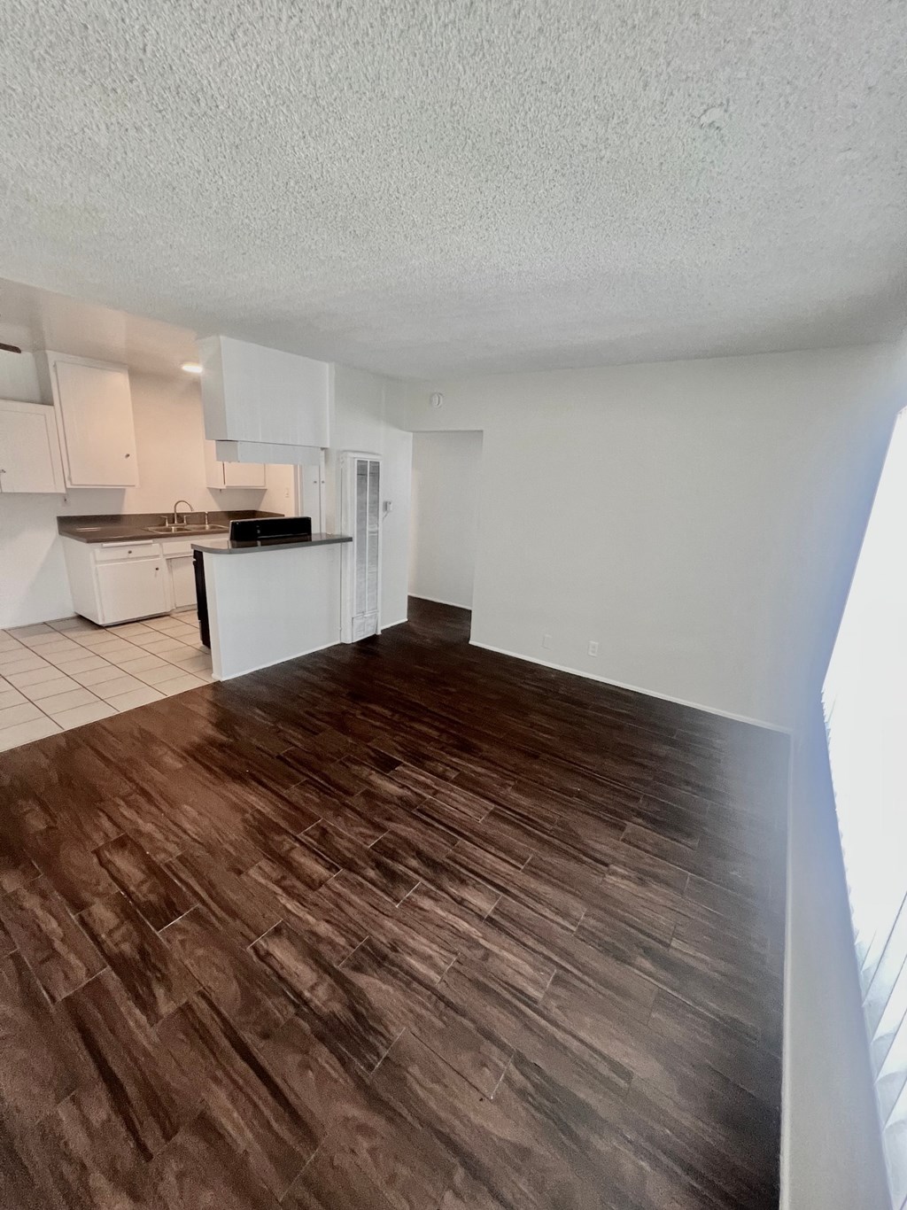 A kitchen with white cabinets and a black microwave.