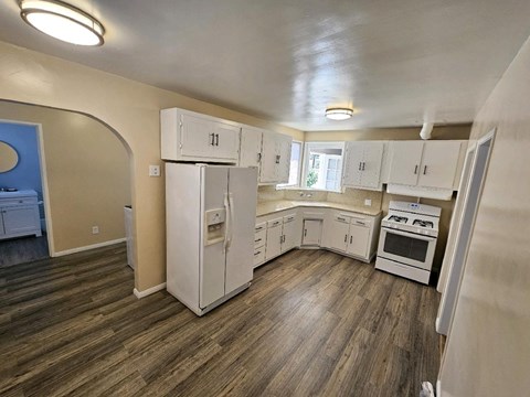 a kitchen with white cabinets and a stove and a refrigerator