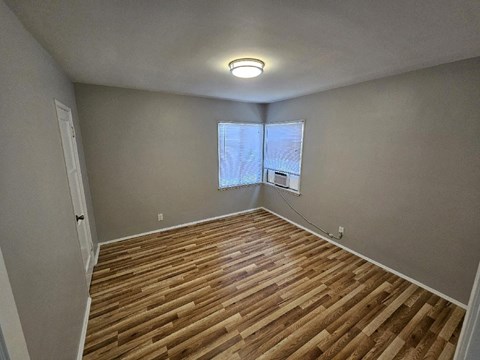 a living room with a hard wood floor and a window
