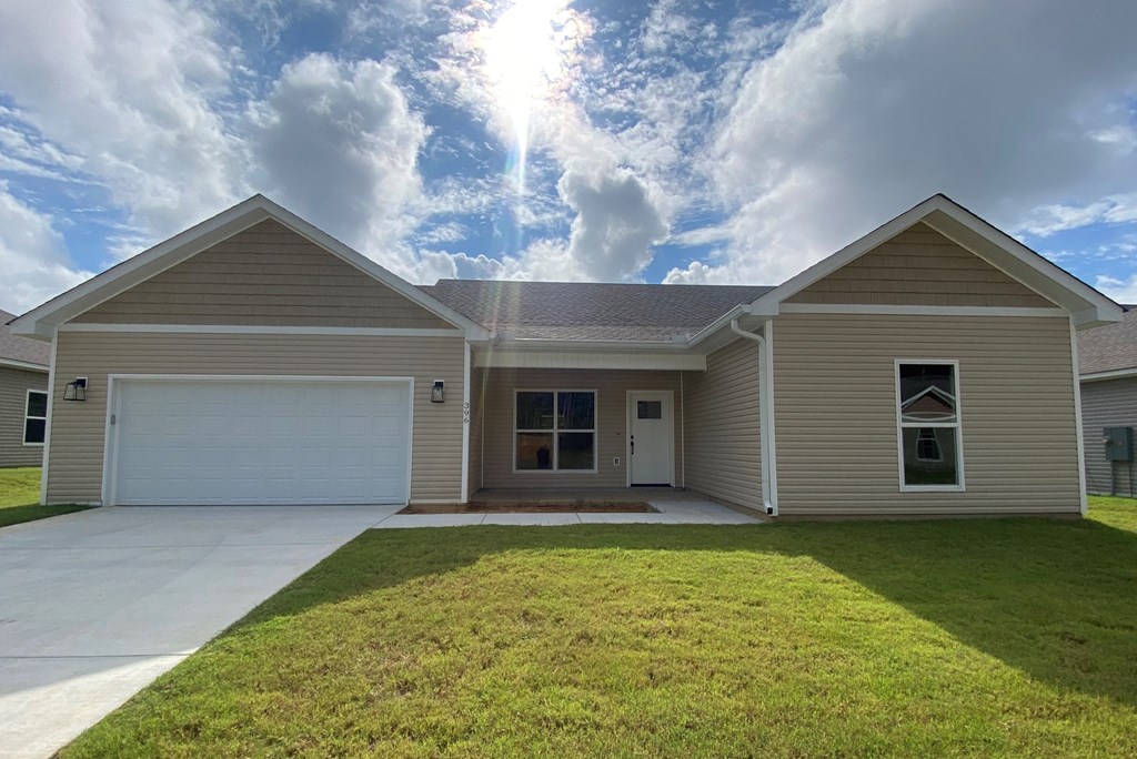 a beige house with a lawn in front of it