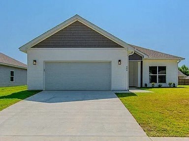 a white house with a garage door on a driveway