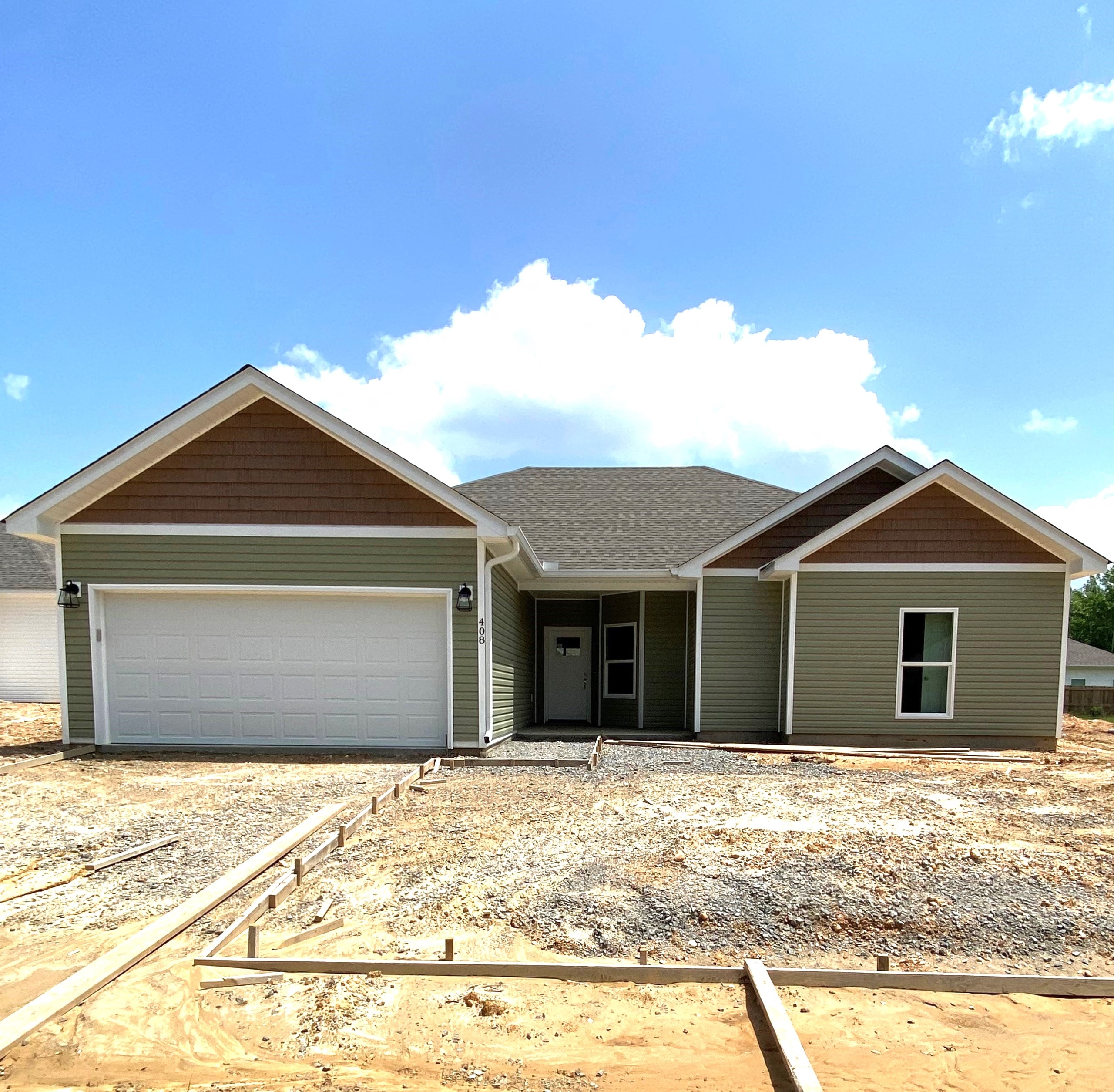 a new house being constructed with a gravel driveway and a garage door