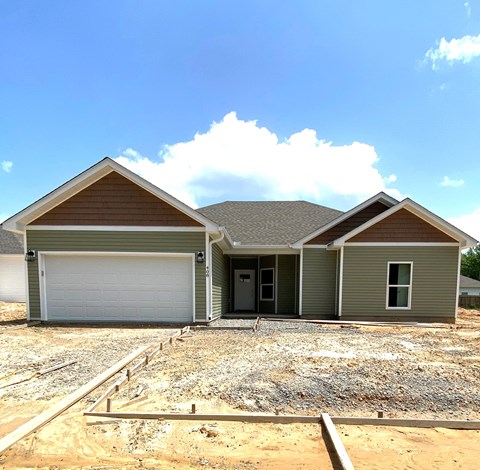 a new house being constructed with a gravel driveway and a garage door