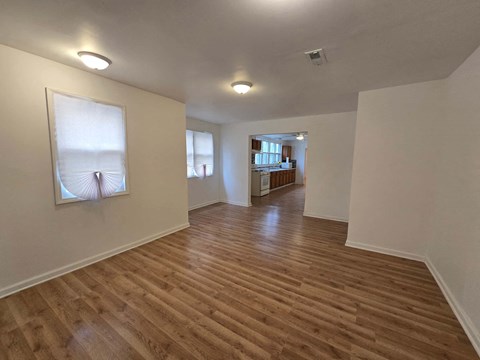 a living room and hallway with wood floors and a painting on the wall