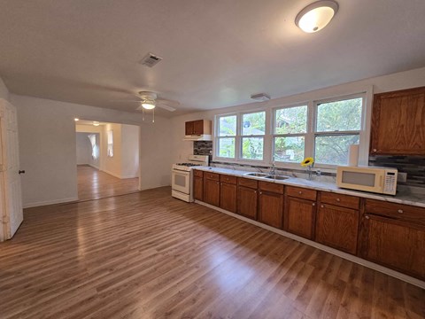 an empty kitchen with a microwave and a sink