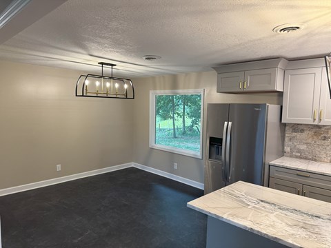 a kitchen with a island and a stainless steel refrigerator