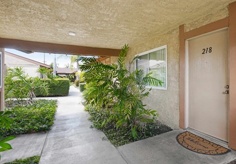 A brown door with a doormat in front of a house.