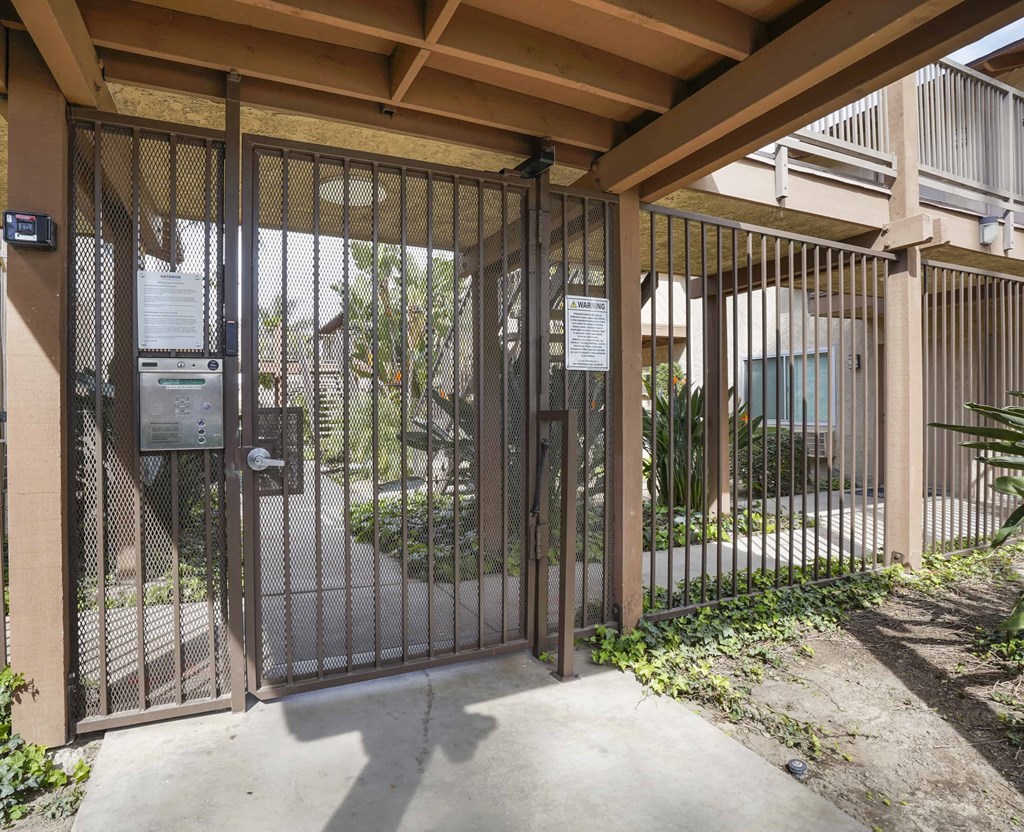 A metal gate with a lock and a keypad entry system.