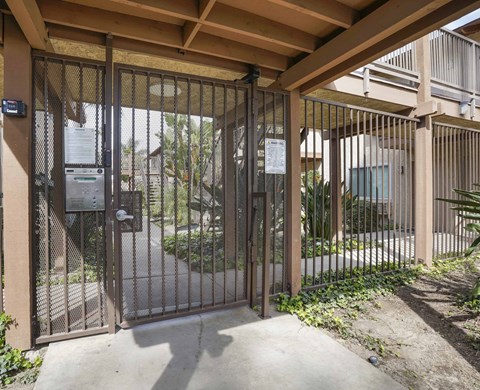 A metal gate with a lock and a keypad entry system.