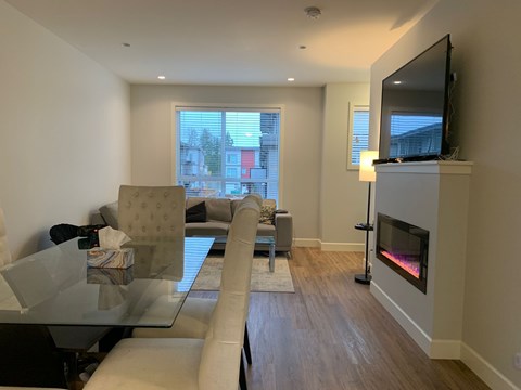 A modern living room with a glass table and a fireplace.