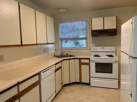 A kitchen with white appliances and cabinets.