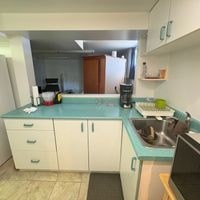 A kitchen with white cabinets and a blue counter.