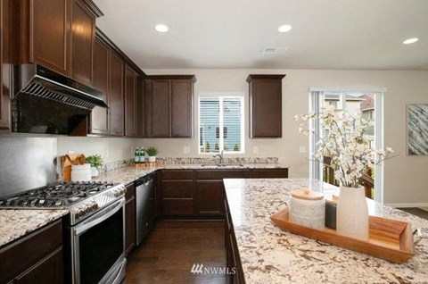 A kitchen with brown cabinets and granite countertops.