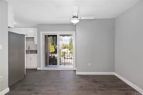 A spacious living room with a sliding glass door leading to a balcony.