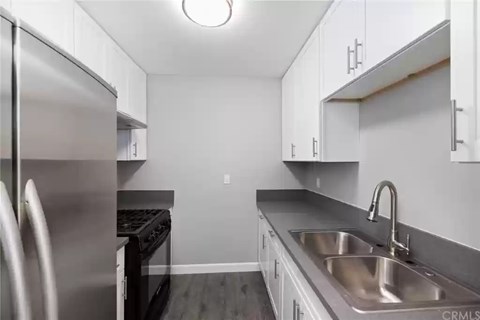 A kitchen with a stainless steel refrigerator and a sink.