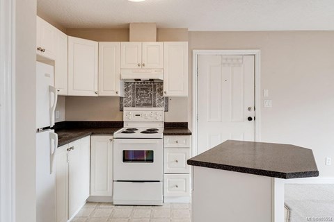 A kitchen with white appliances and cabinets.
