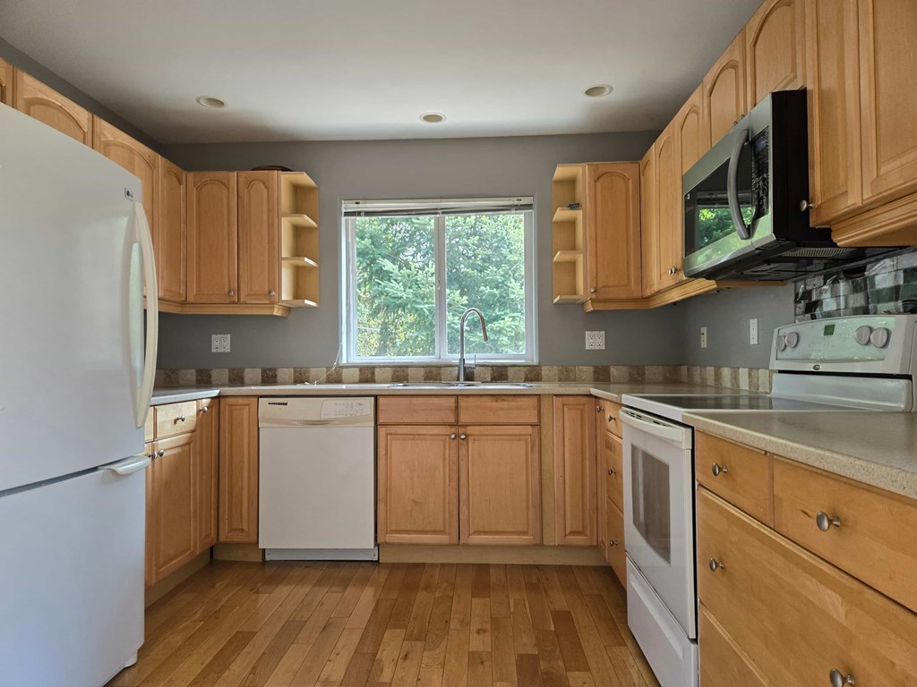 A kitchen with wooden cabinets and a white refrigerator.
