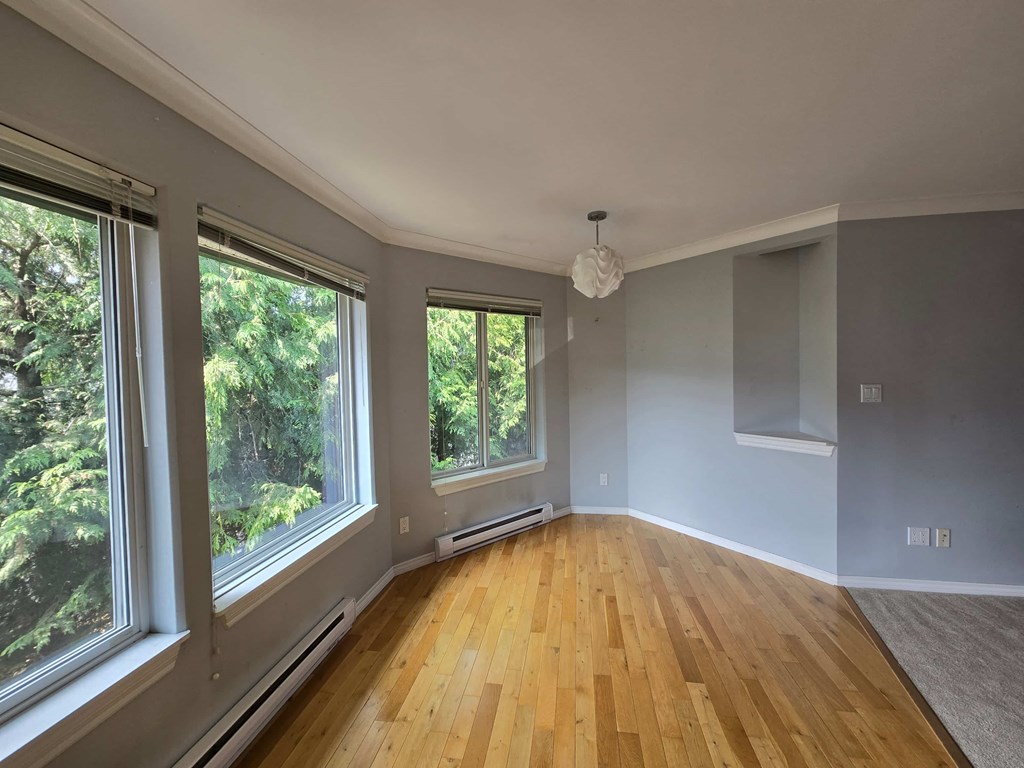 A room with wooden floors and large windows.
