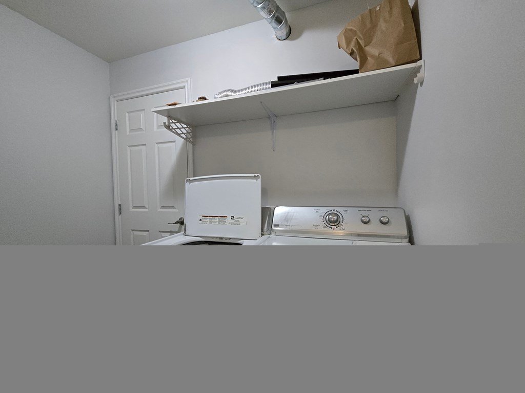 A white oven is sitting under a shelf in a kitchen.