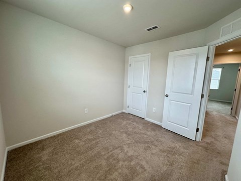 a bedroom with a carpeted floor and white doors