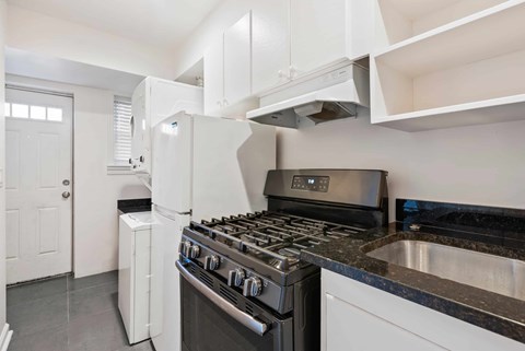 A modern kitchen with a stove top oven and a refrigerator.