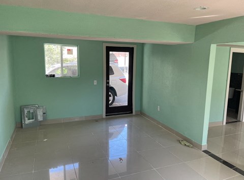 a living room with green walls and a white tiled floor