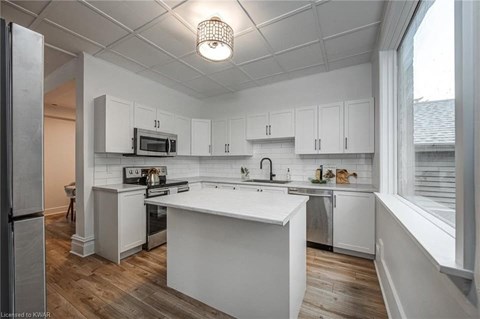 A kitchen with white cabinets and a white island.
