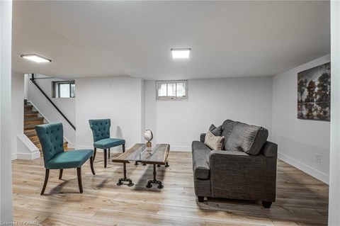 A living room with a grey couch, two chairs and a coffee table.