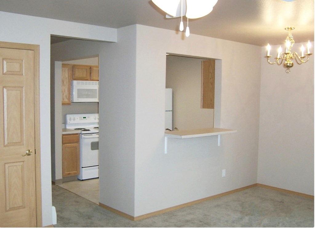 A kitchen area with a stove, oven, and microwave.