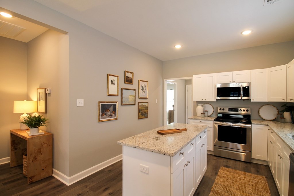 a kitchen with white cabinets and a granite counter top